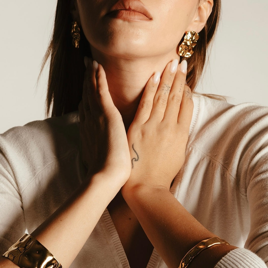 Translation missing: it.Modella indossa orecchini e bracciali dorati Collezione Firenze, gioielli eleganti ispirati all’arte rinascimentale italiana: Firenze