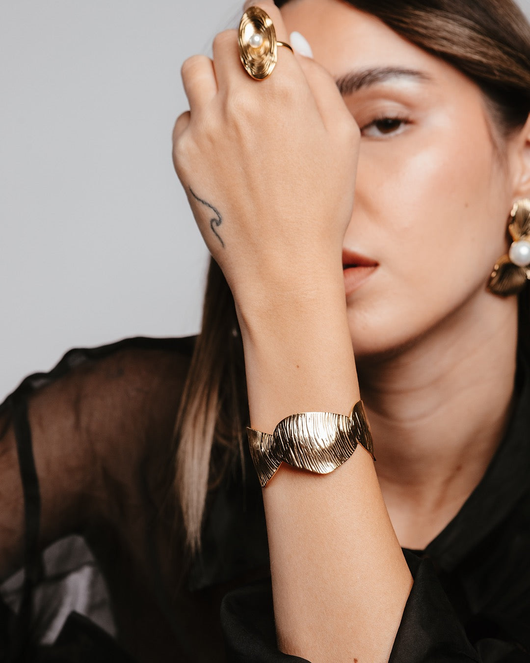 Modella indossa il Bracciale Cairo Foglia Oro Medema, accessorio elegante in acciaio inox placcato oro 18k