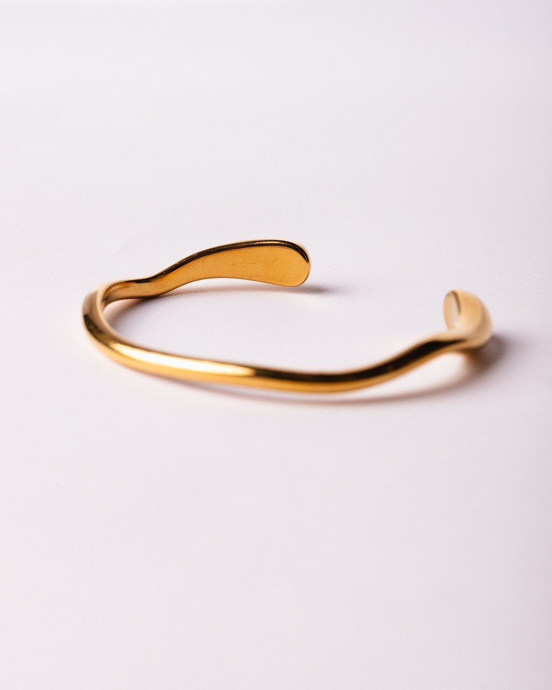 Dettaglio del bracciale aperto e regolabile, finitura lucida ispirata a forme organiche