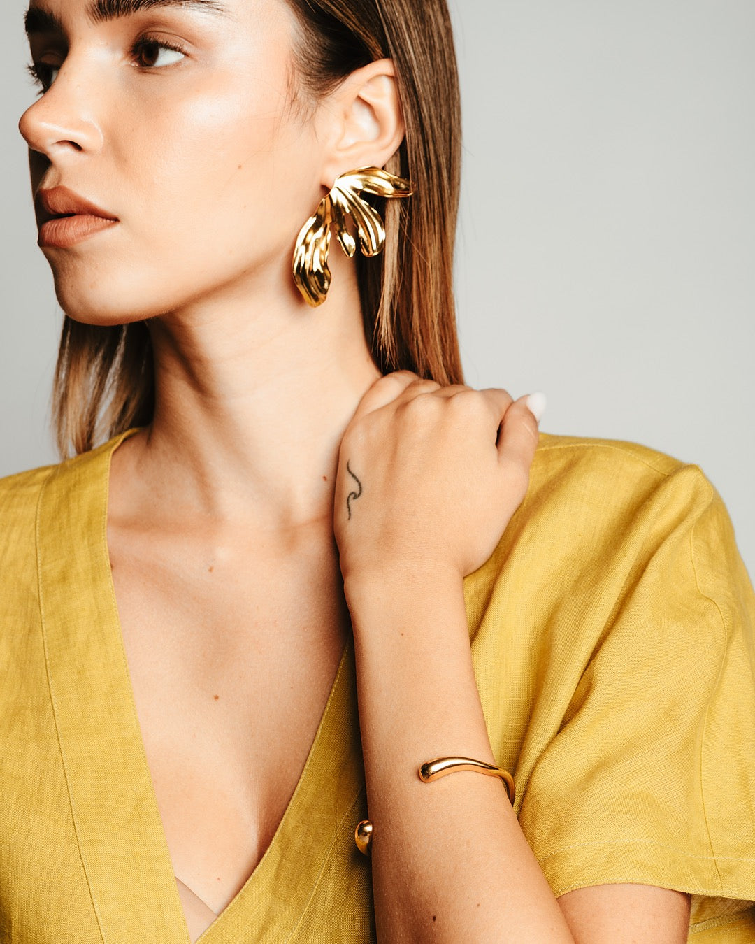 Modella con Orecchini Medema, look luminoso e femminile con design scultoreo