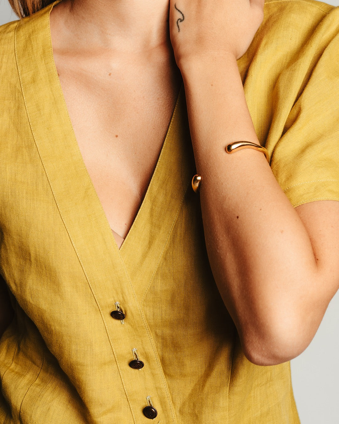 Primo piano al polso con il bracciale dorato Medema, look quotidiano raffinato