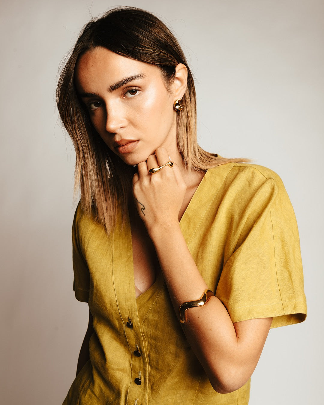 Bracciale Firenze Curva di Luce Medema indossato, luminosità dorata che valorizza il look con carattere e fluidità