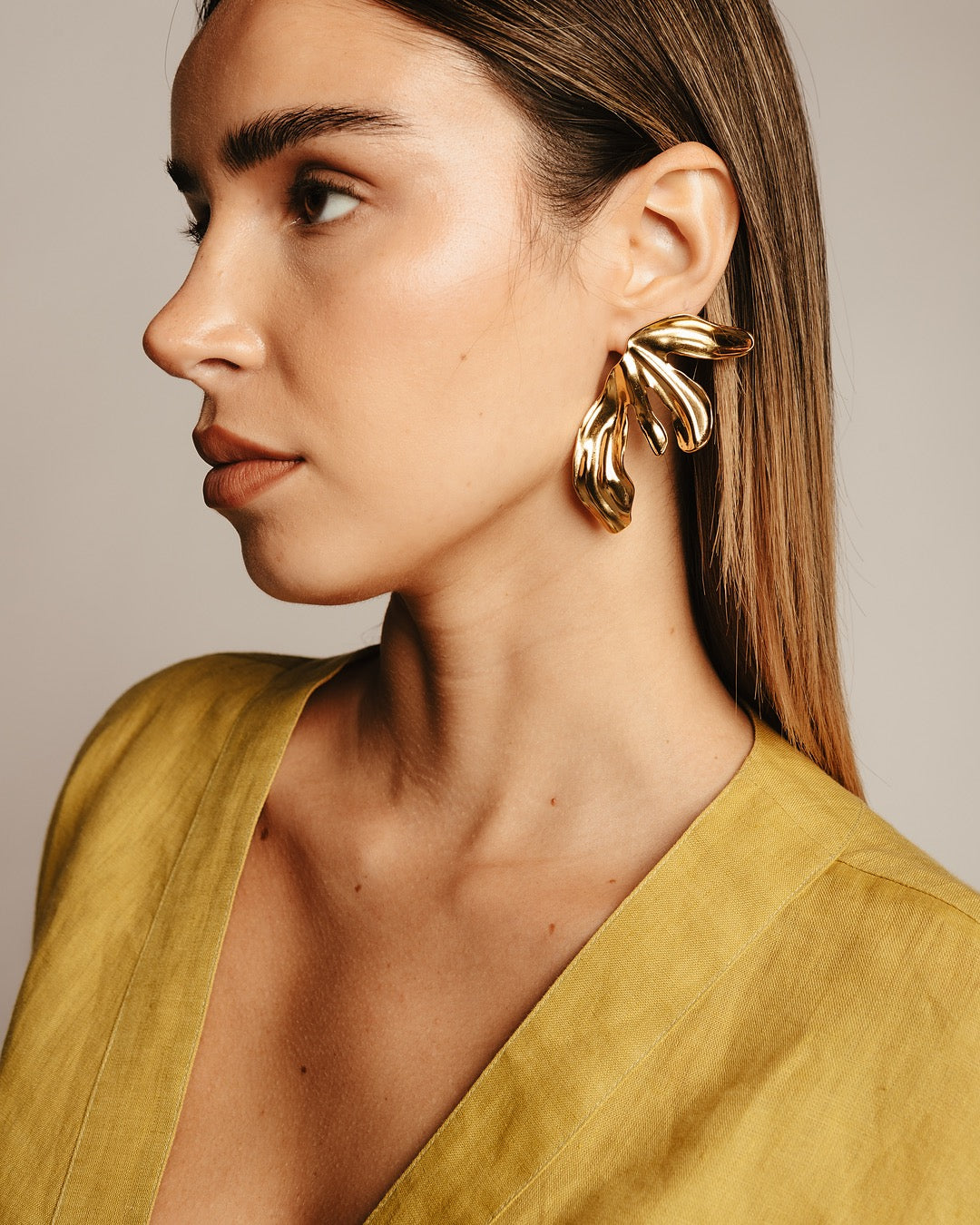 Modella indossa gli Orecchini Cairo Foglia Scultorea Medema, eleganza contemporanea e raffinata