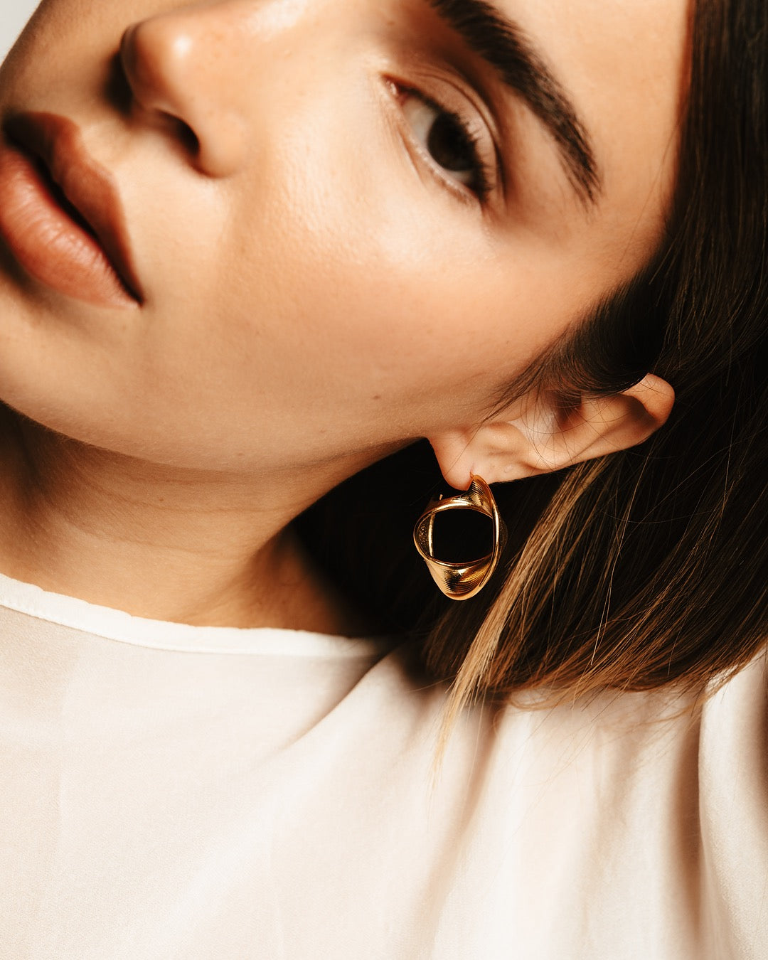 Modella indossa gli Orecchini Cairo Avvolgenti Medema, eleganza moderna e luminosa