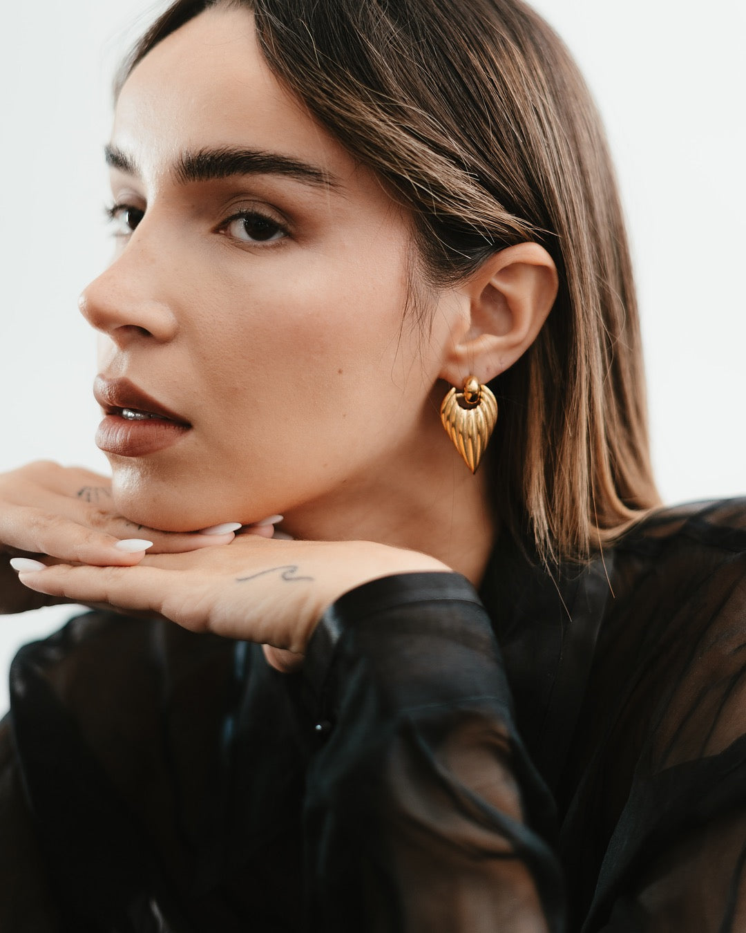 Modella indossa gli Orecchini Roma Scultorei Oro Medema, eleganza moderna e raffinata