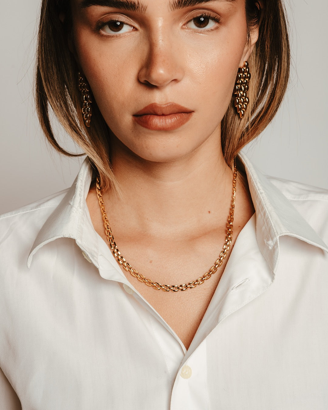 Modella indossa gli Orecchini Roma Intreccio Dorato Medema, eleganza strutturata e moderna