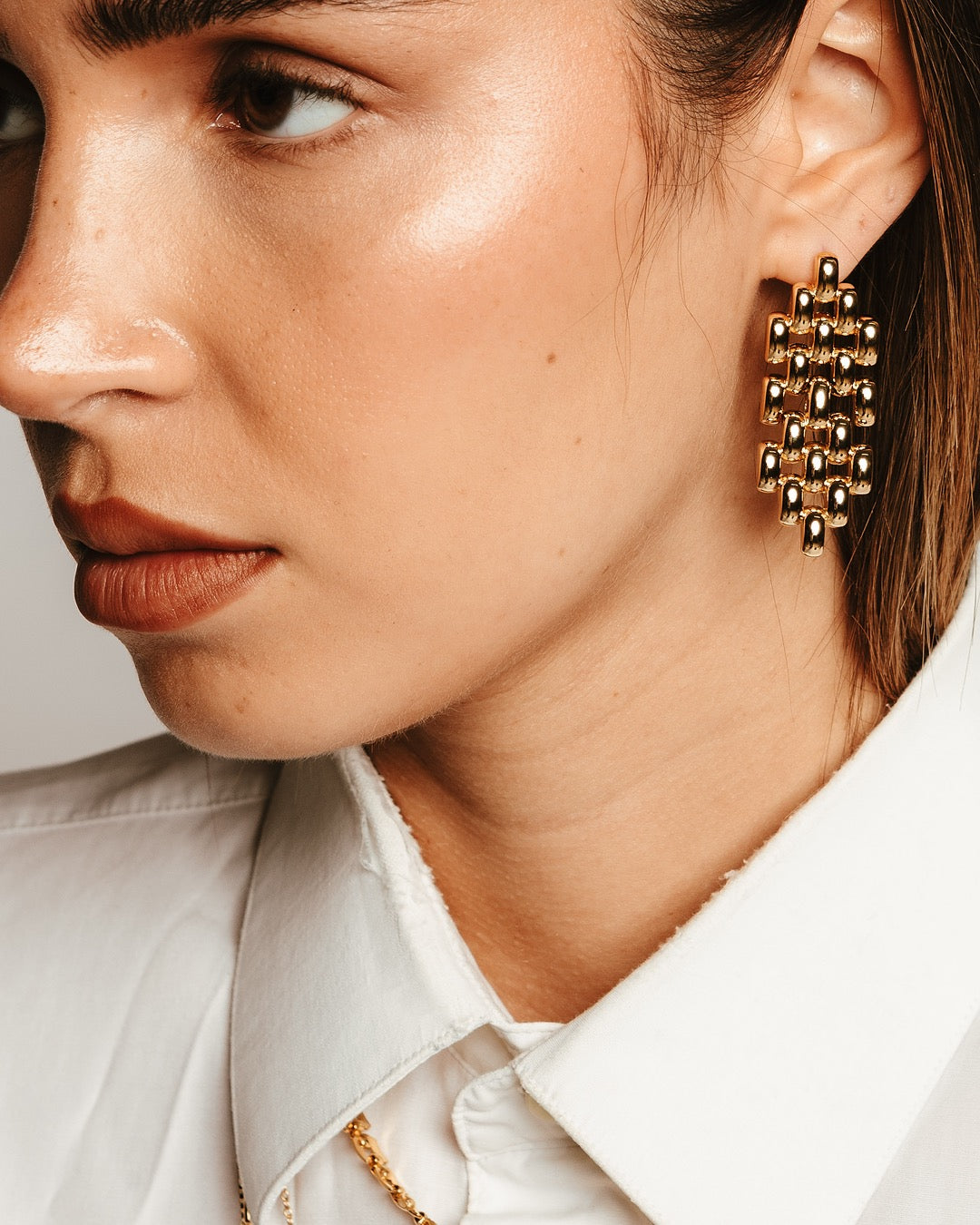 Primo piano del viso con Orecchini Medema Roma, design intrecciato e riflessi dorati