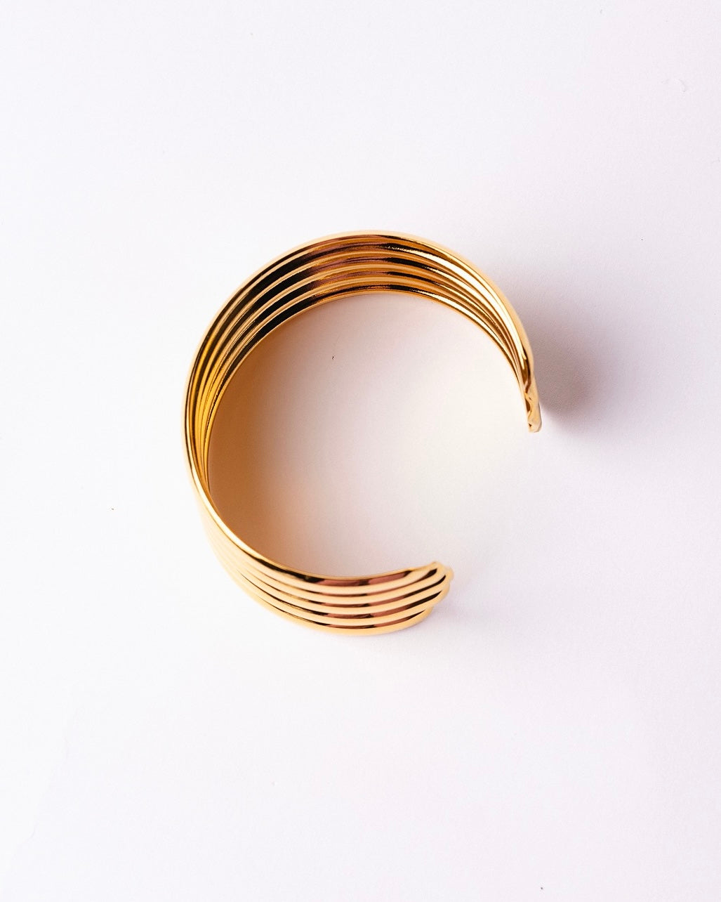 Bracciale Medema Roma Colonne Dorate su fondo chiaro, equilibrio tra forza e raffinatezza senza tempo