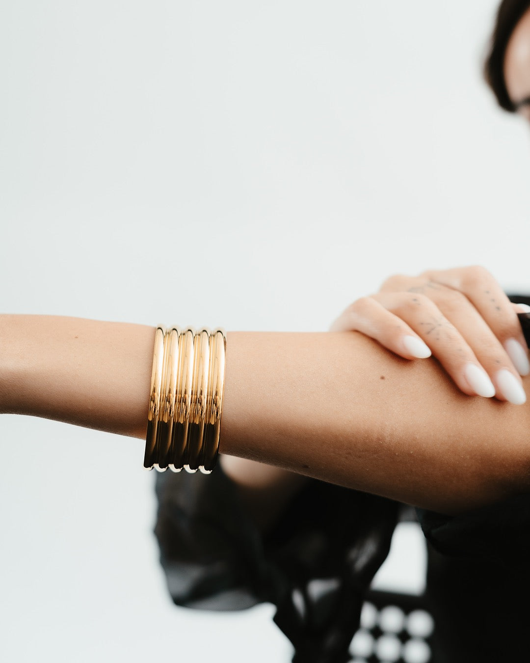 Modella indossa il Bracciale Roma Colonne Dorate Medema, eleganza scultorea ispirata ai templi romani