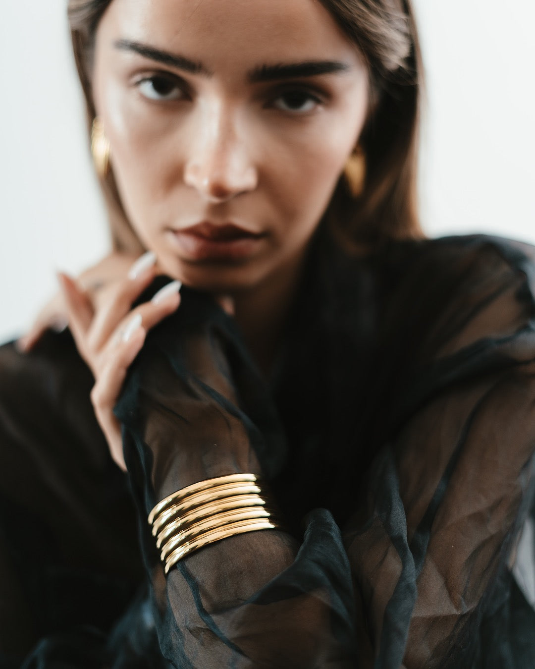 Primo piano della modella con Bracciale dorato Medema Roma, design architettonico e linee armoniose