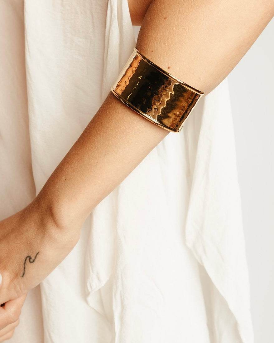 Modella indossa il Bracciale Roma Scultoreo Medema, fascino architettonico e raffinata eleganza dorata