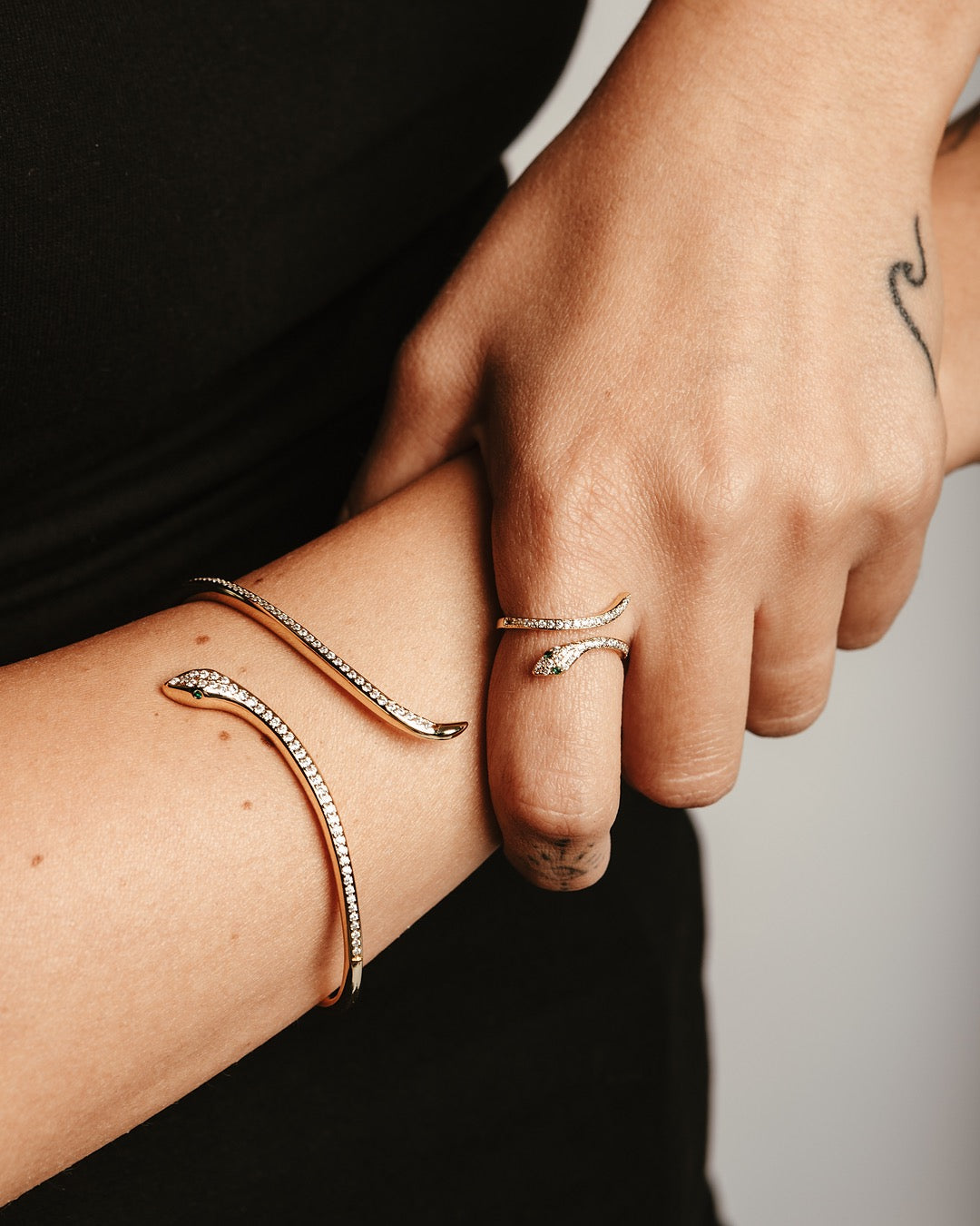 Dettaglio polso con bracciale serpente dorato e zirconi luminosi Medema