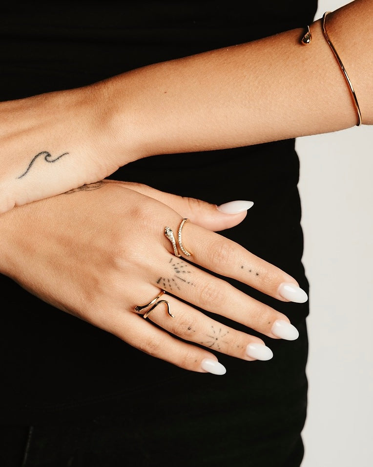 Dettaglio mano con anello serpente dorato e zirconi luminosi Medema