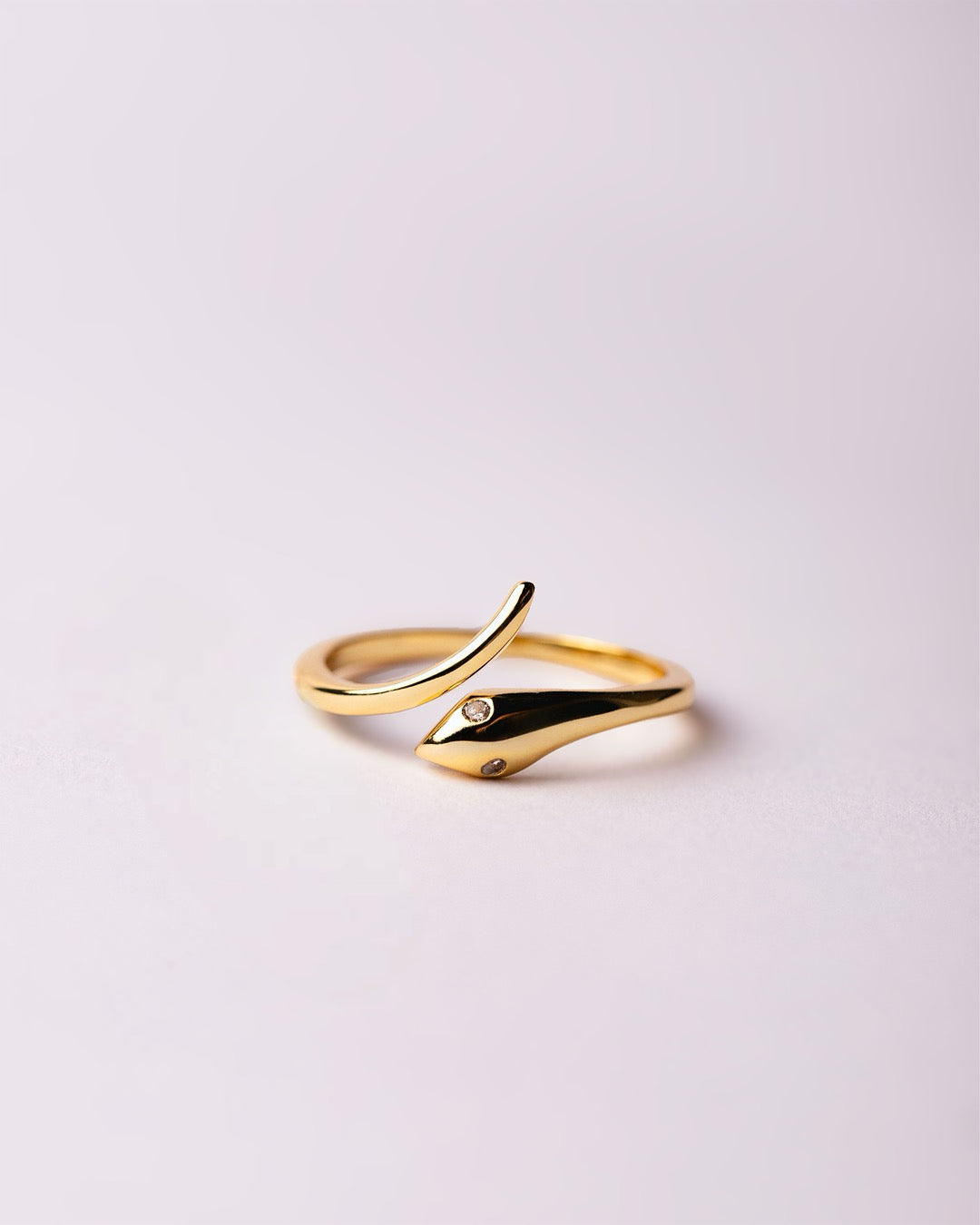 Dettaglio anello dorato a forma di serpente con zirconi bianchi sugli occhi | Medema gioielli