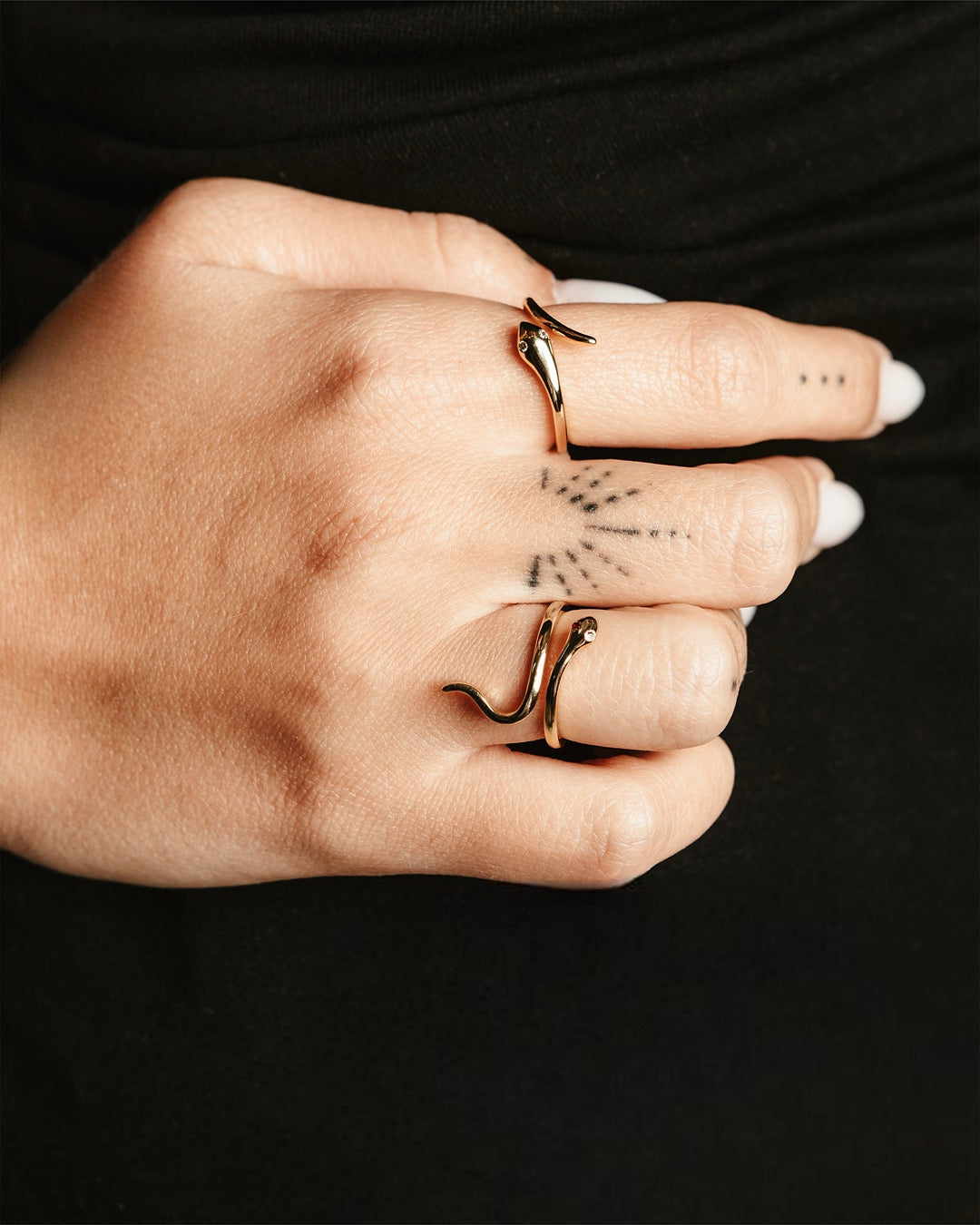 Dettaglio mano femminile con anello serpente dorato Medema, design raffinato e moderno