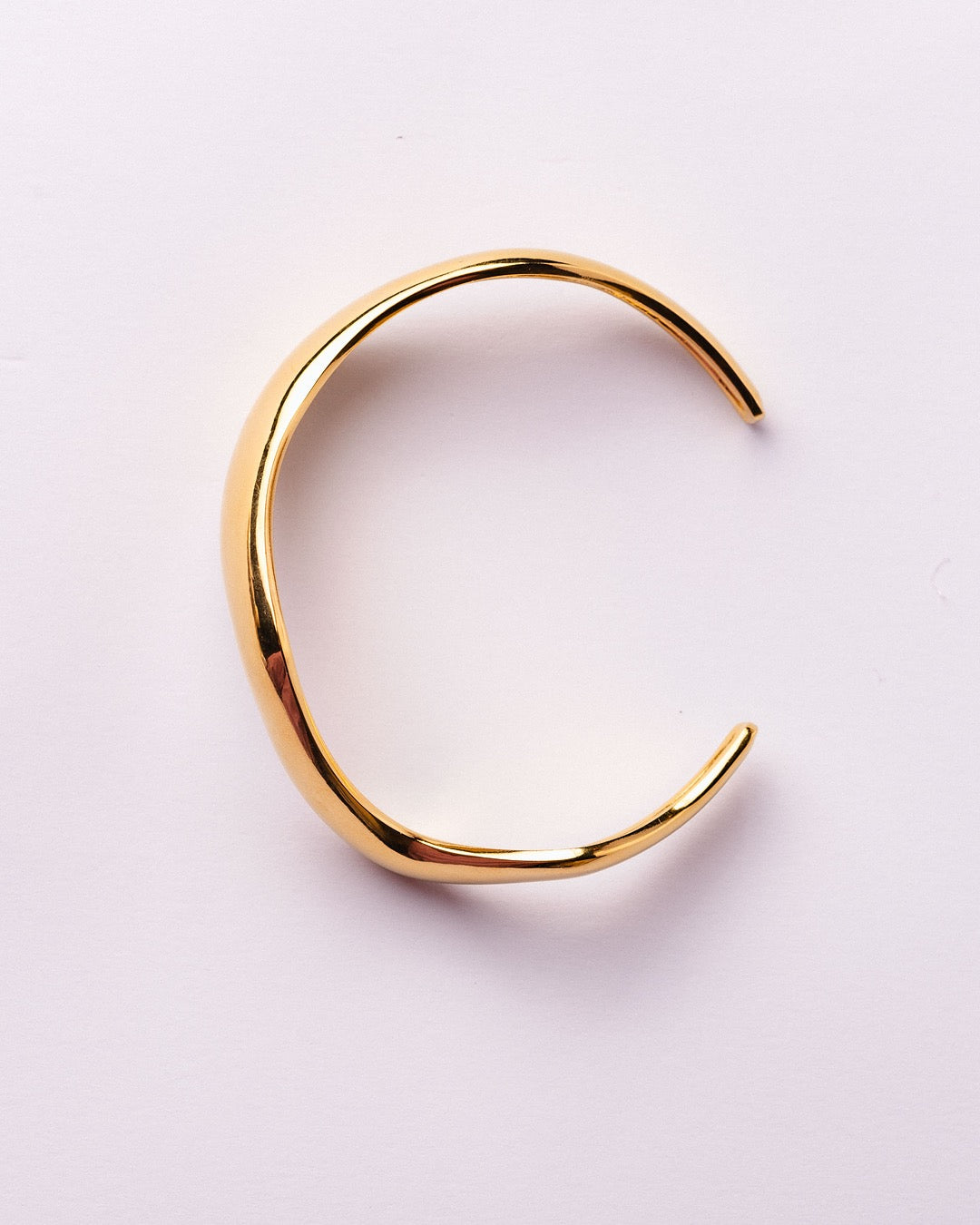 Bracciale Firenze Curva di Luce Medema fotografato su fondo neutro, linee fluide e apertura laterale elegante