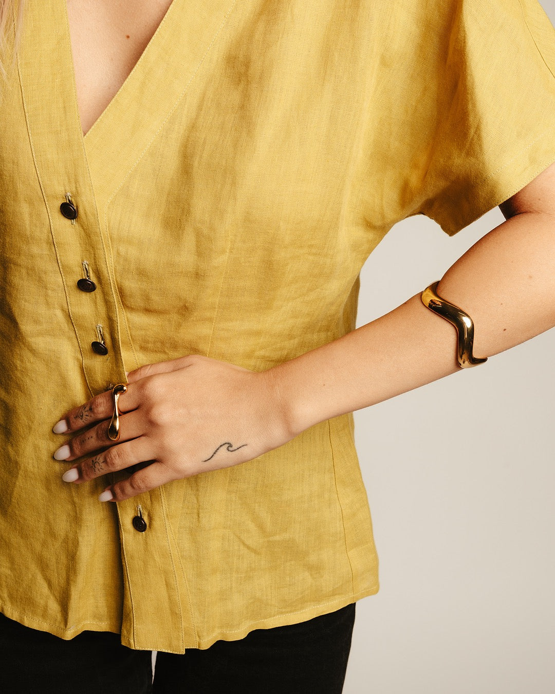 Dettaglio al polso del Bracciale dorato Medema, design sinuoso e superficie specchiata