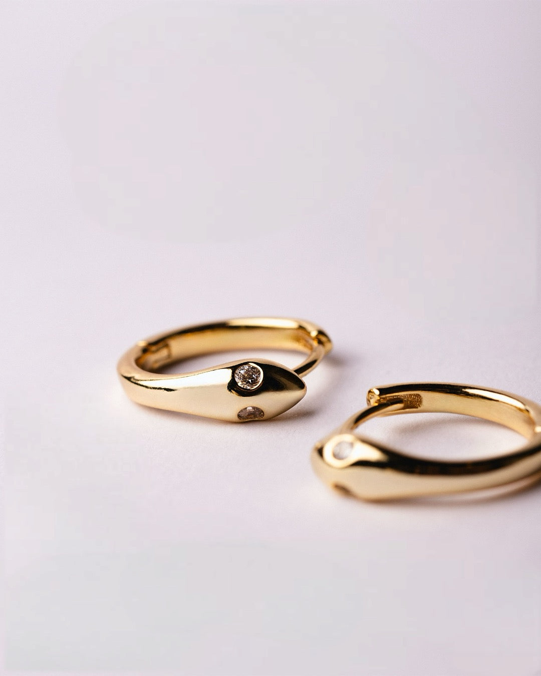 Coppia di orecchini dorati a cerchio design serpente con chiusura a scatto