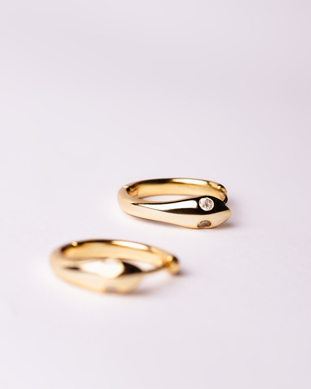 Dettaglio orecchini serpente dorato con zirconi incastonati negli occhi