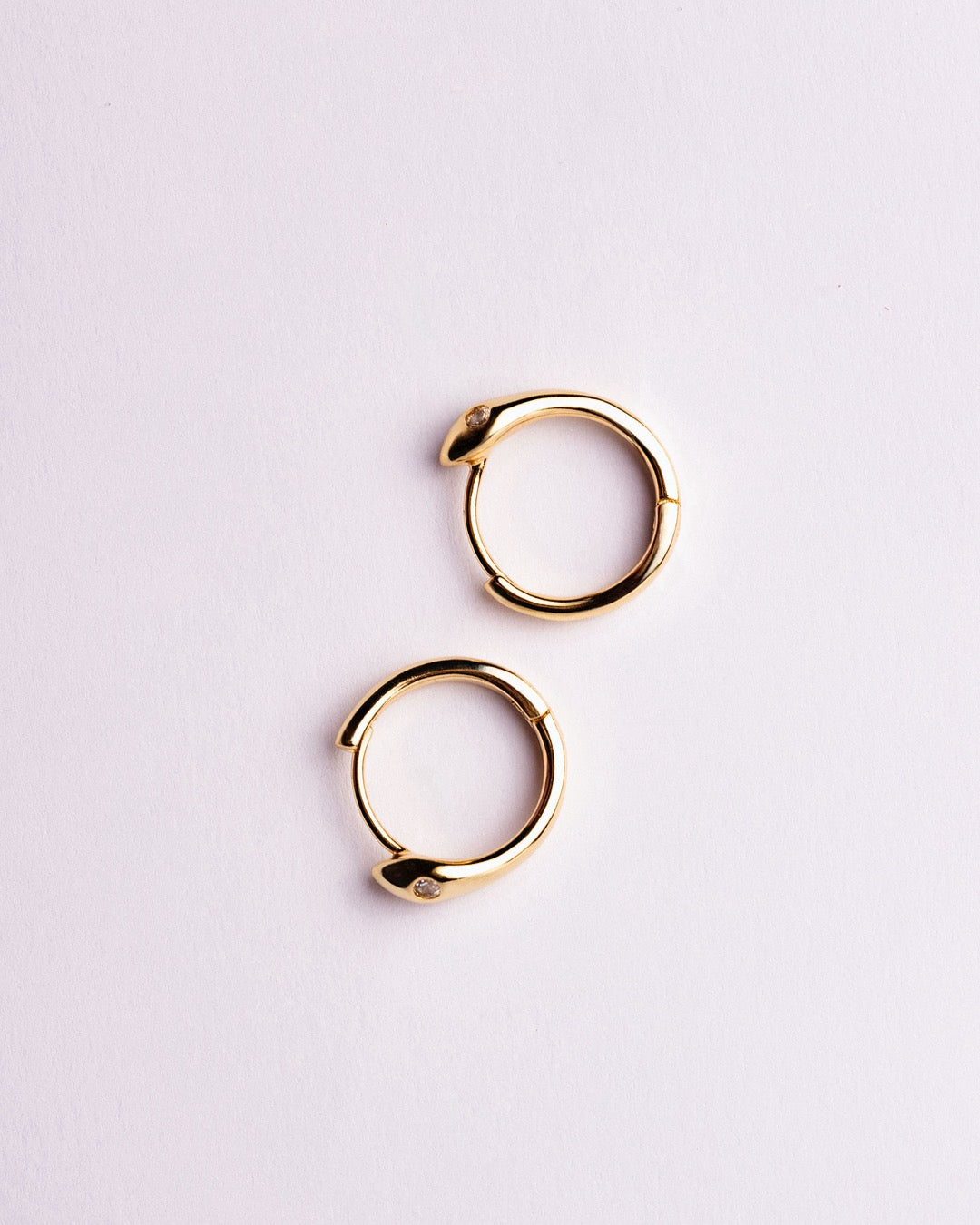 Orecchini Bangkok dorati Medema esposti in primo piano con riflessi luminosi