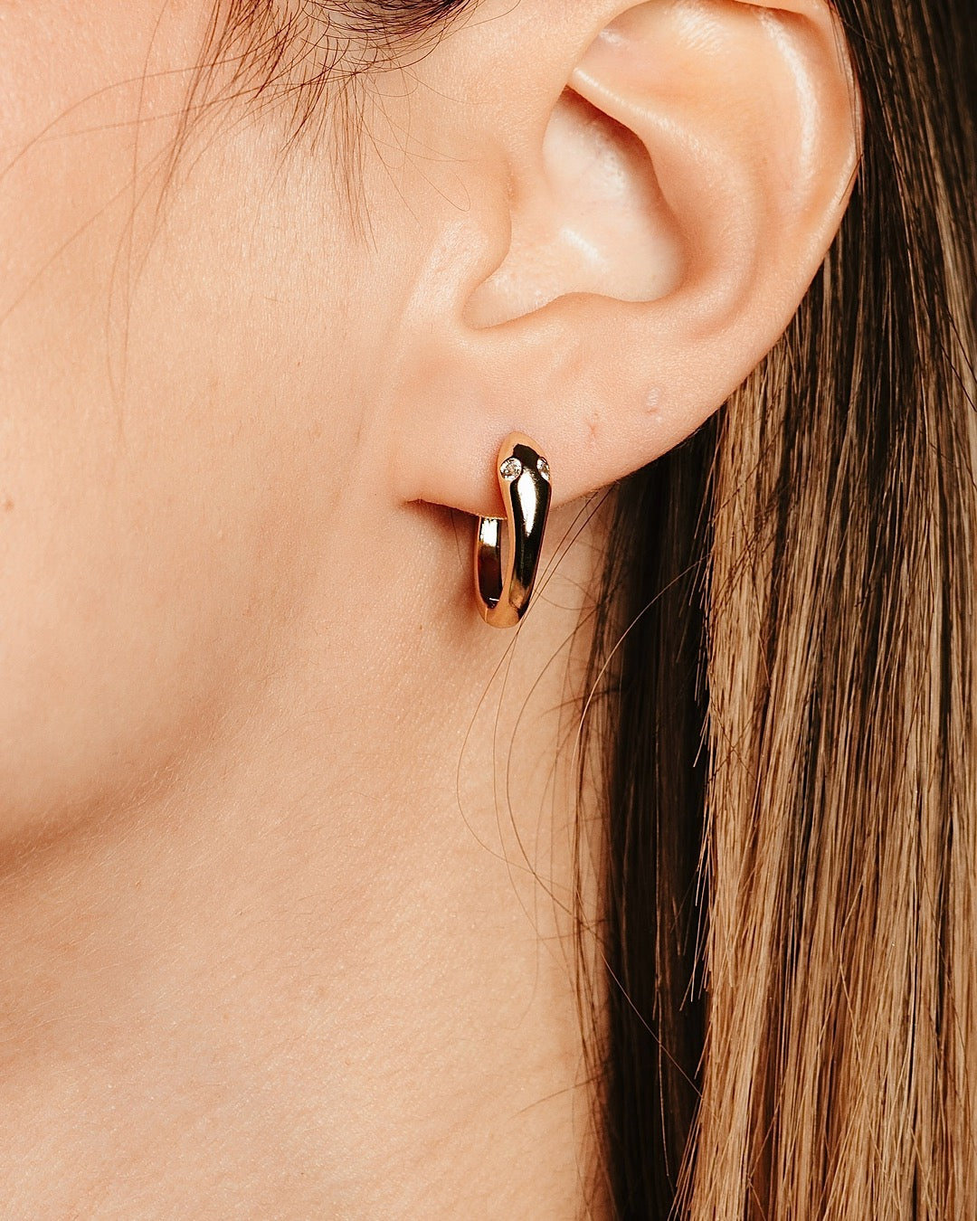 Primo piano del viso con Orecchini Serpente Dorato Medema, look sofisticato e moderno