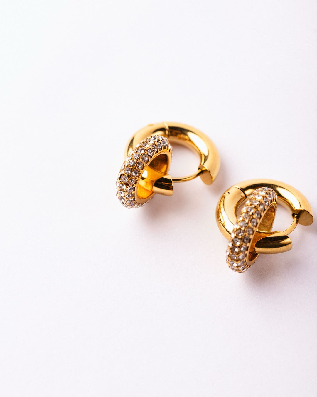 Orecchini Medema Copenhagen su fondo chiaro, eleganza senza tempo con cerchio luminoso e dettagli fini