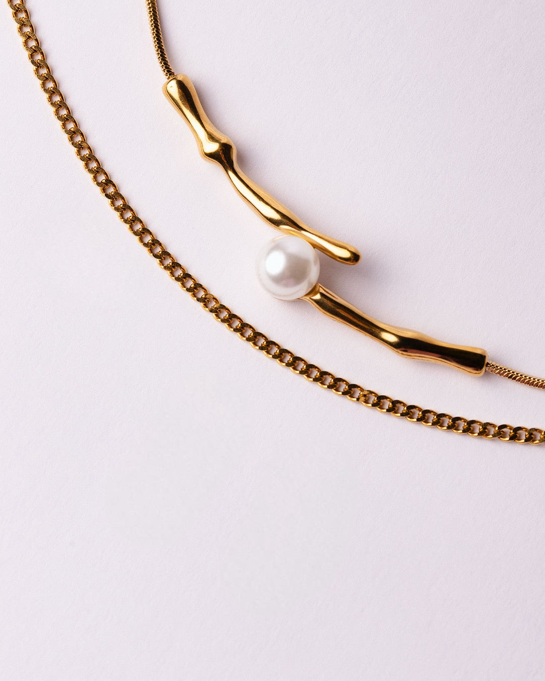 Dettaglio della Collana Atene Ramo di Luce Medema su sfondo chiaro, rami dorati e perla effetto madreperla