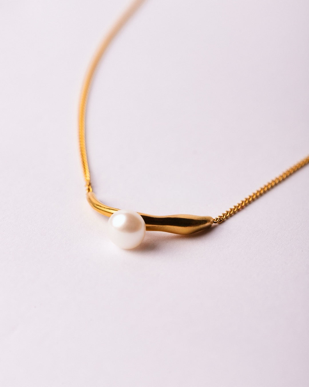 Collana Atene Perla Dorata Medema su sfondo chiaro, finitura lucida e perla centrale elegante