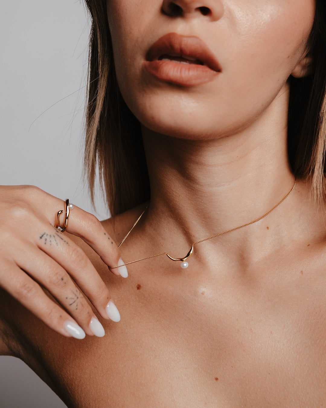 Primo piano del collo con Collana Medema Atene Perla Dorata, luce dorata e stile raffinato