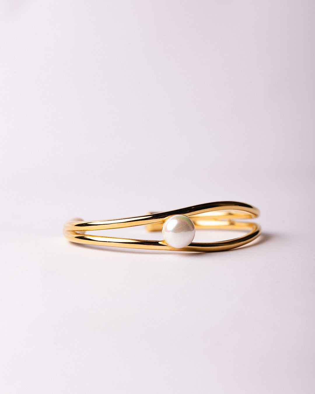 Bracciale Atene Perla di Luce Medema su sfondo chiaro, luce calda e finitura lucente