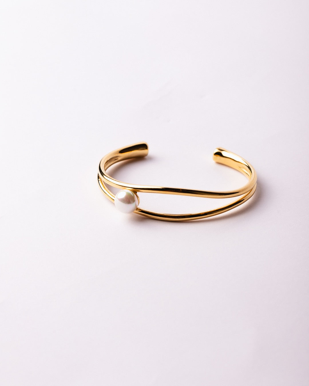 Bracciale Atene Perla di Luce Medema su sfondo chiaro, luce calda e finitura lucente