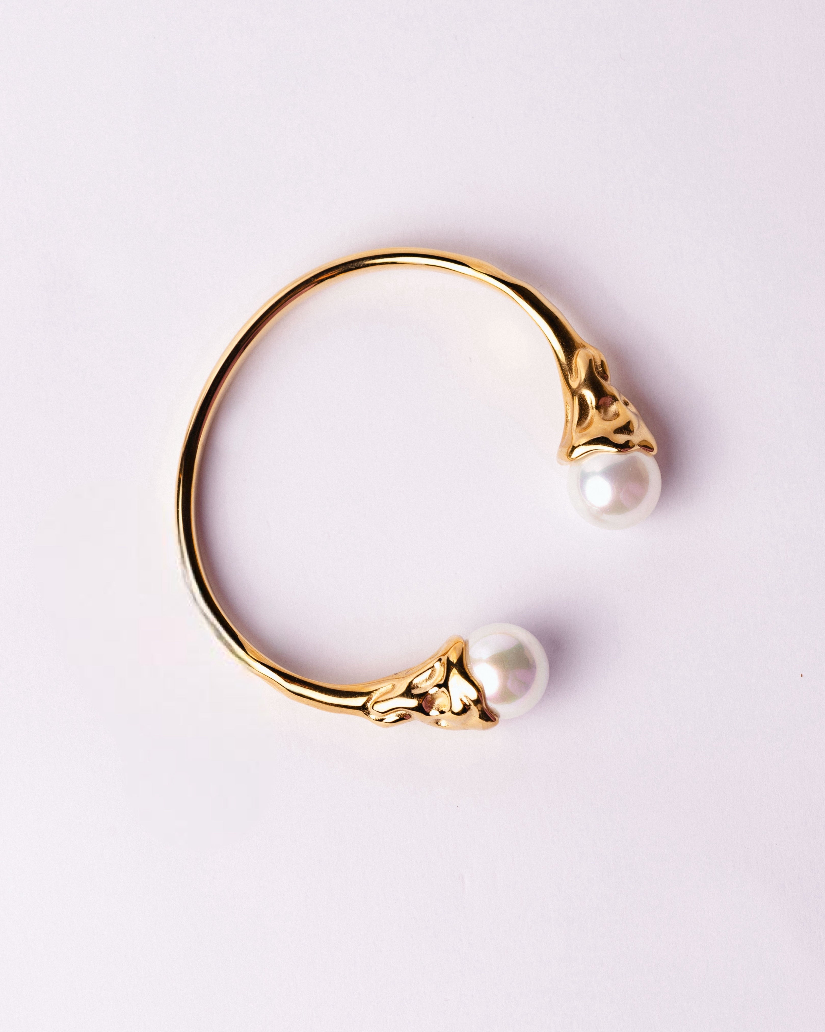 Bracciale Medema Atene su sfondo chiaro, estremità scolpite e luce naturale elegante