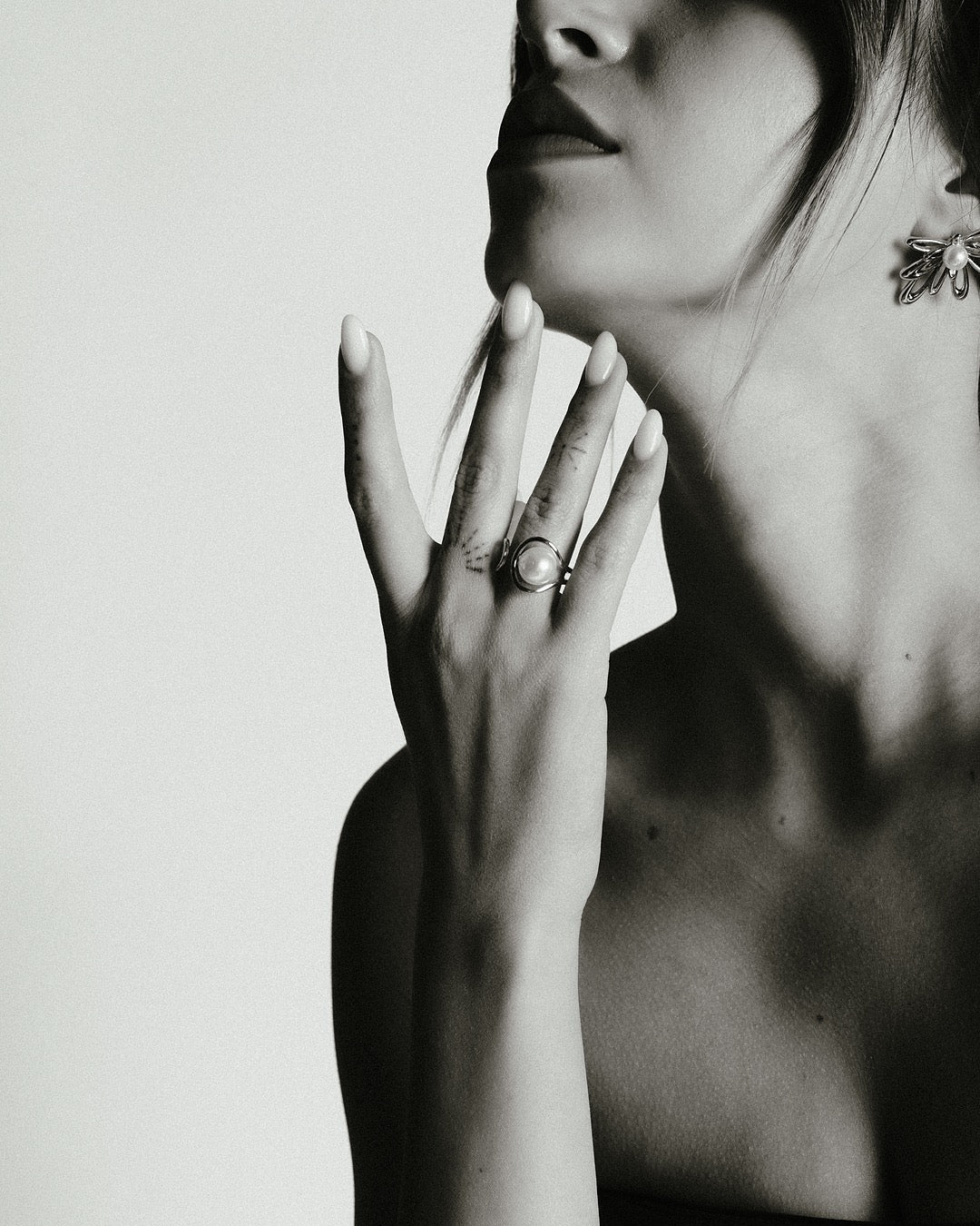 Modella indossa l’Anello Atene Spirale di Luce Medema, eleganza raffinata e naturale - bianco e nero