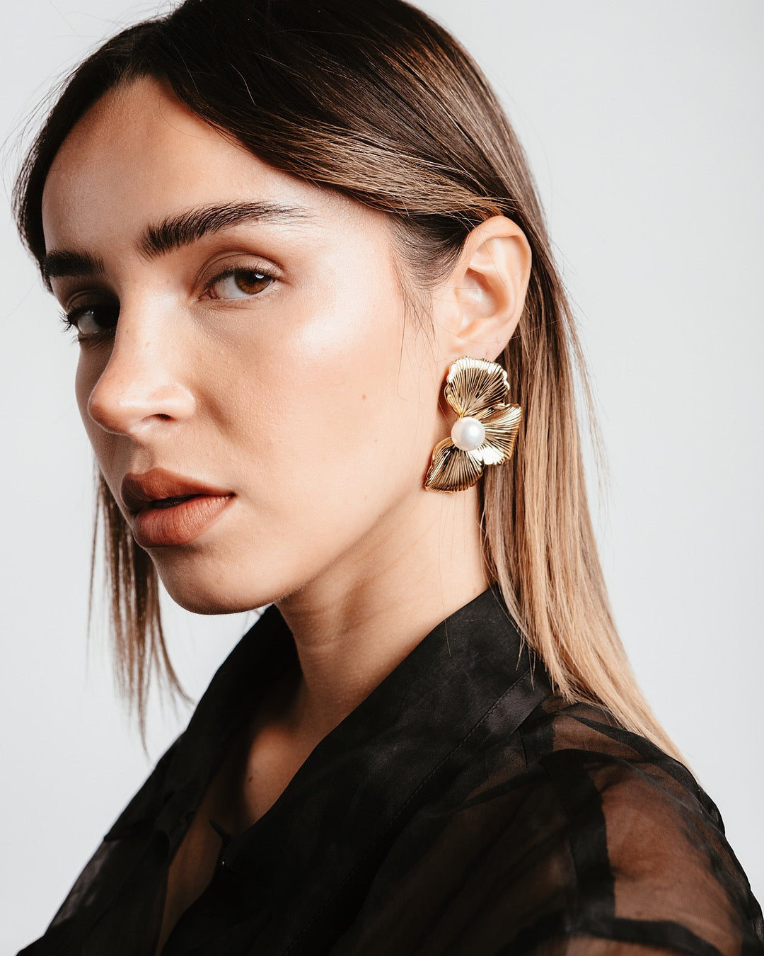 Modella indossa gli Orecchini Atene Petali di Luce Medema, eleganza dorata e naturale