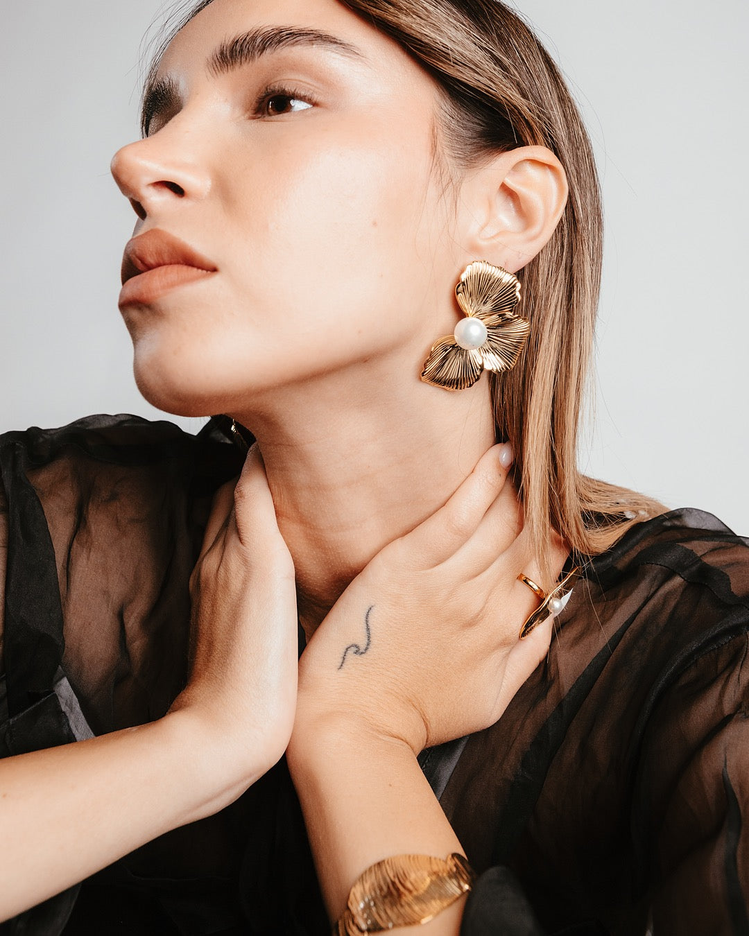 Dettaglio della modella con Orecchini Medema, design floreale con perla centrale