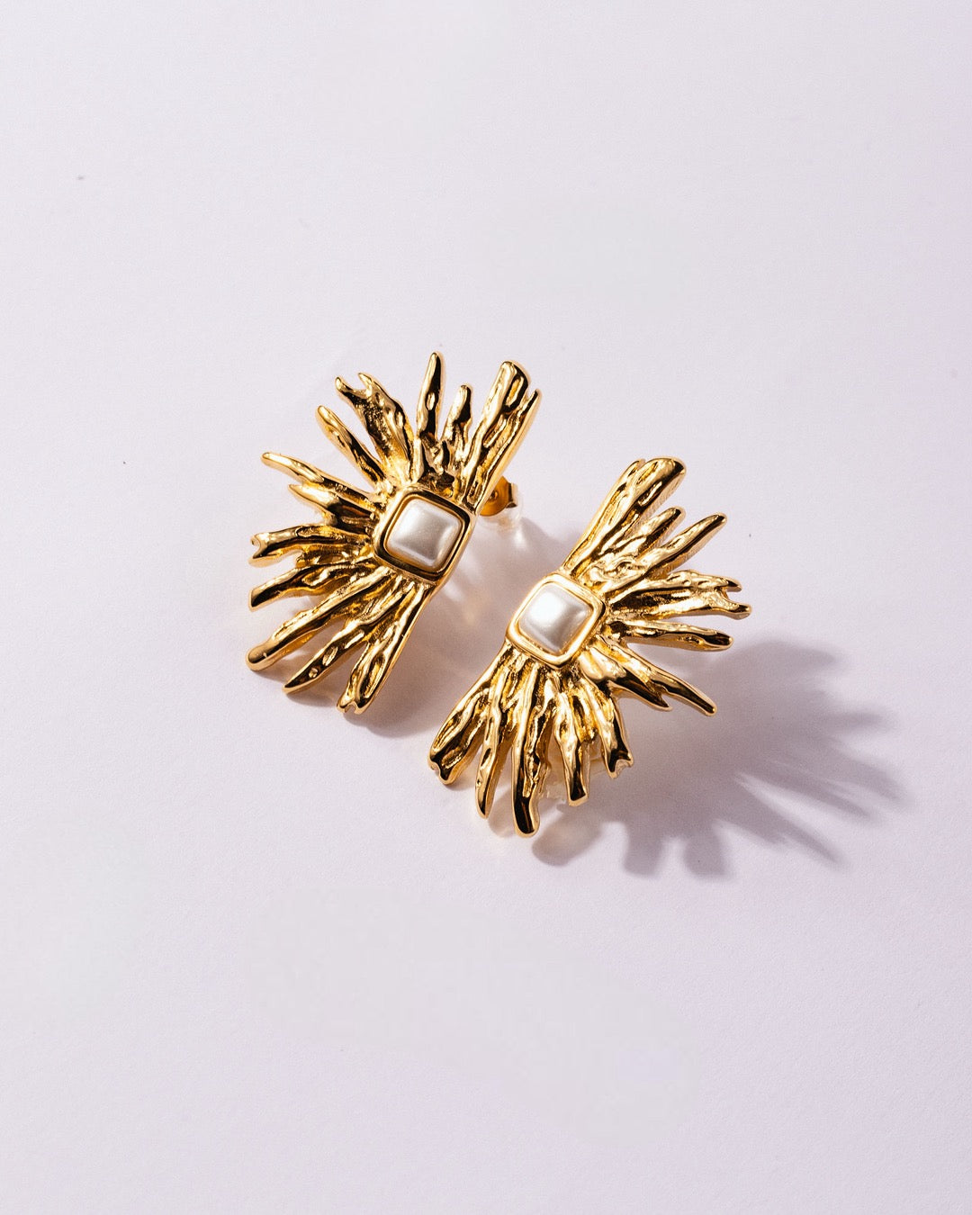 Orecchini Atene Fiamma Dorata Medema su sfondo chiaro, ispirati alle forme della natura