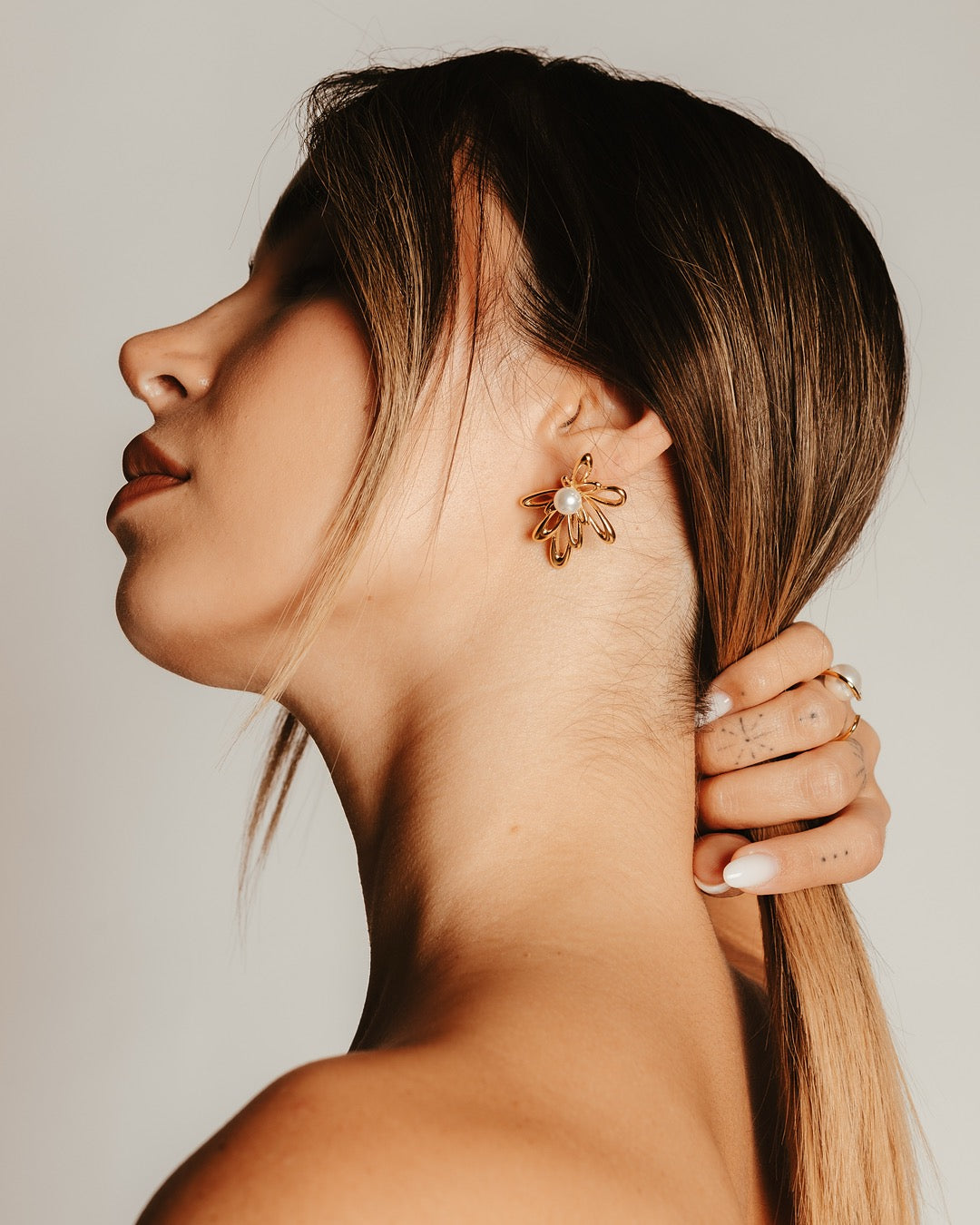 Primo piano laterale della modella con Orecchini Medema Atene Fiore Dorato, stile femminile e delicato